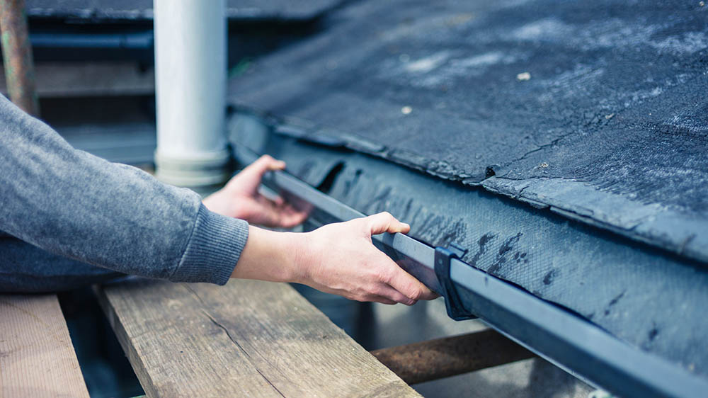 Gutter being repaired before scheduling home inspection services 