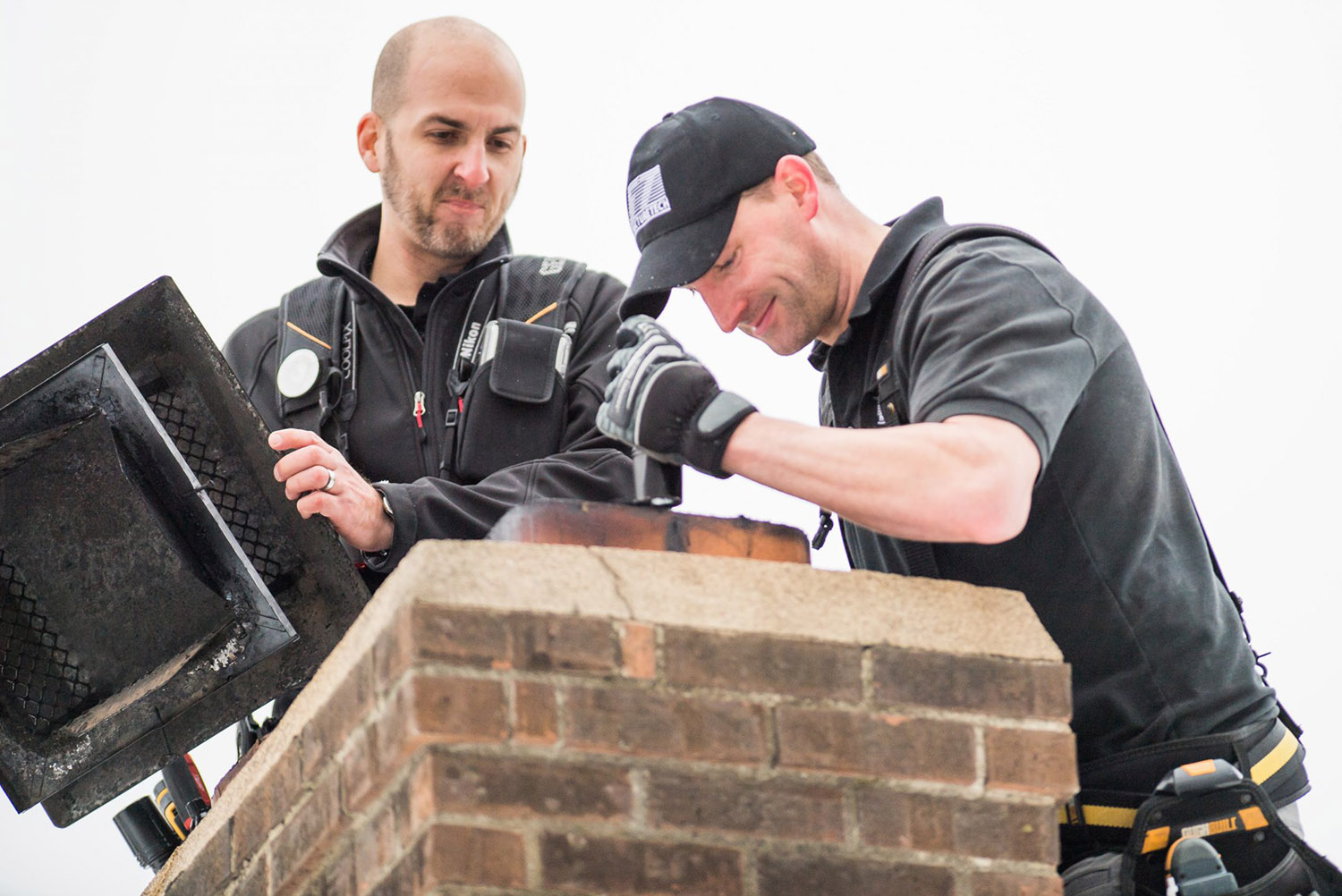 Our certified home inspectors checking the chimney on the roof of a house